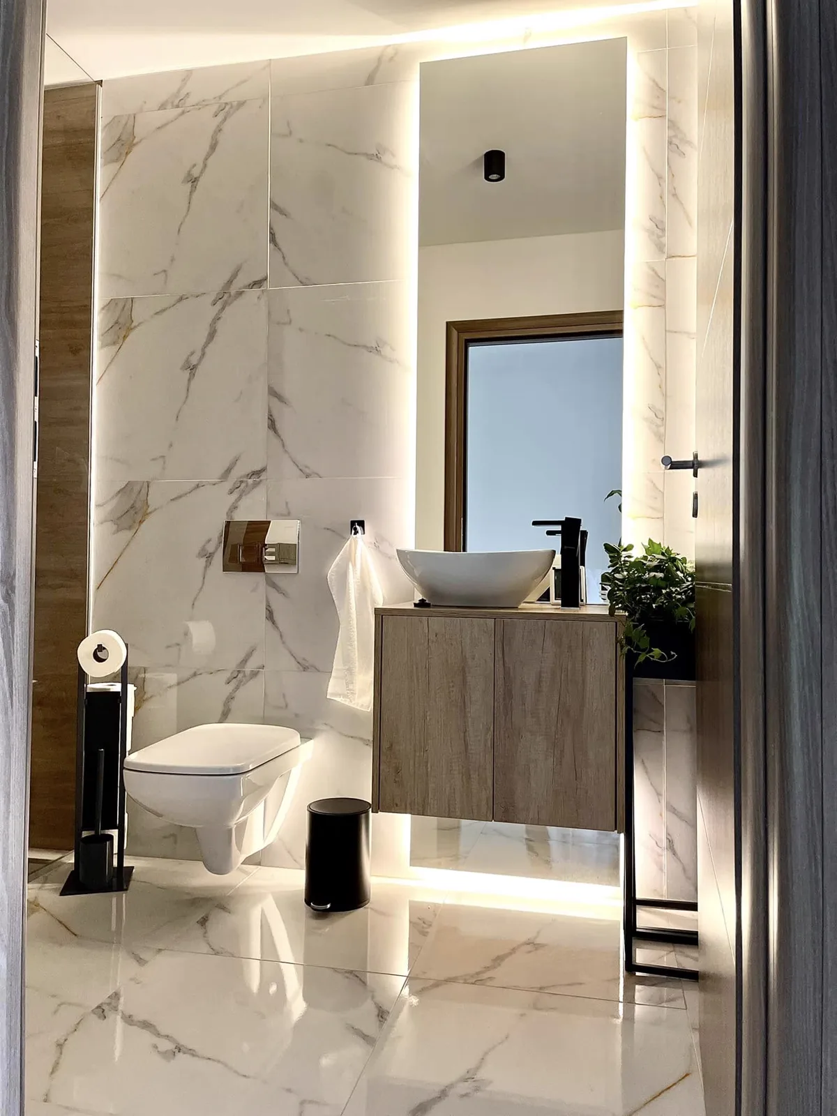 Baie modernă cu faianță elegantă și lumini ambientale