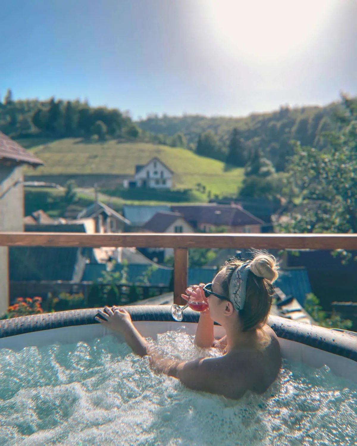 Outdoor hot tub with view over the village and green hills
