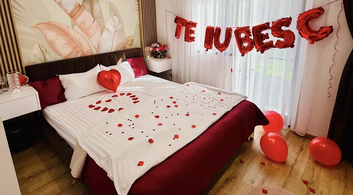 Dormitor decorat romantic cu petale și baloane Te Iubesc
