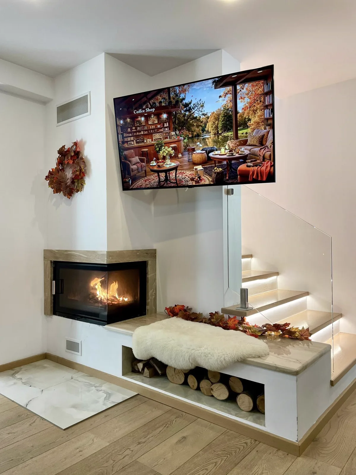 Șemineu cu TV deasupra și scară LED — decor de toamnă
