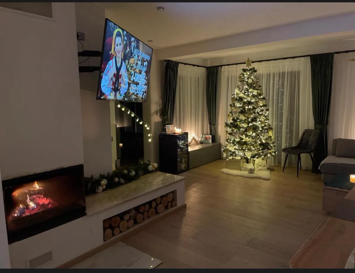 Living de Crăciun cu brad auriu și șemineu aprins