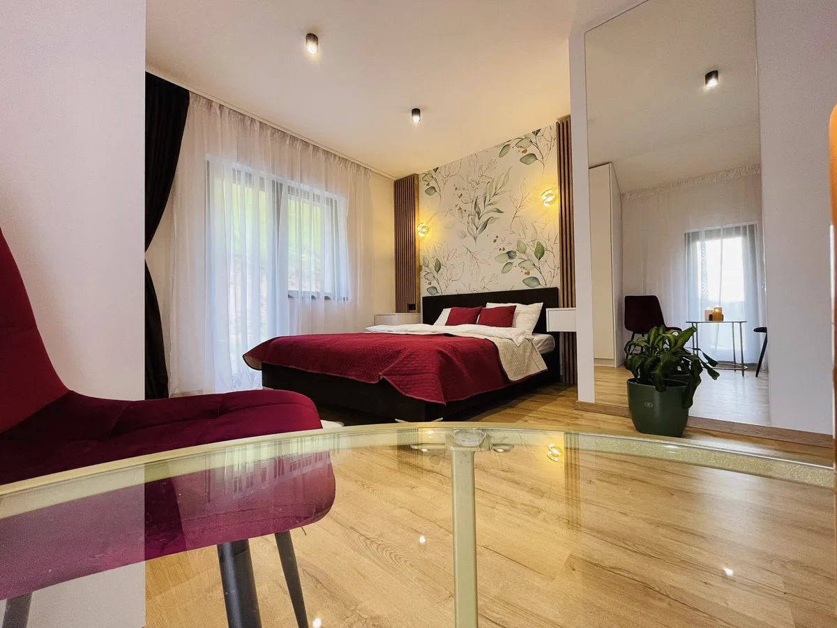 Bedroom 2 with floral wallpaper and burgundy bed linen